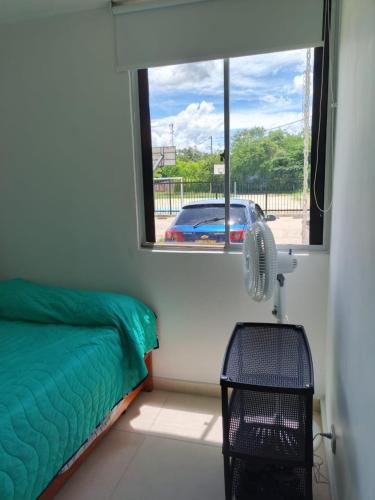 a bedroom with a window and a bed and a fan at APARTAMENTO RICAURTE Cund in Ricaurte