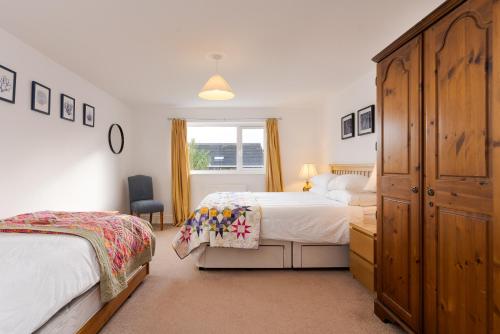 um quarto com duas camas e uma cômoda em Arwerydd em Aberporth