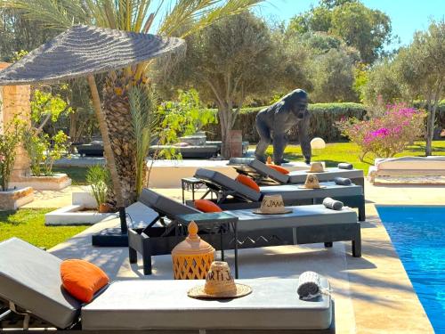 a pool with lounge chairs and a statue of a lion at Palais Tiyana in Al Ghar