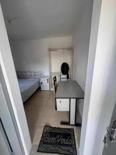a small room with a desk and a bed at Família Ebeneze in Nova Friburgo