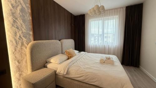 um quarto com uma cama com uma cadeira e uma janela em Vanilla Studio Apartment 2 em Timişoara