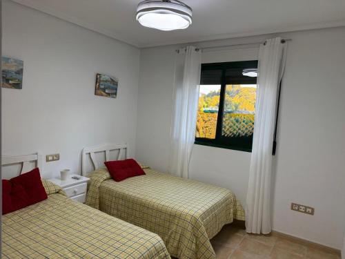 due letti in una stanza con finestra di Casa tres soles a Calasparra