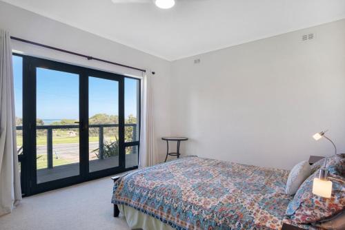 a bedroom with a bed and a large sliding glass door at Island View in Hayborough