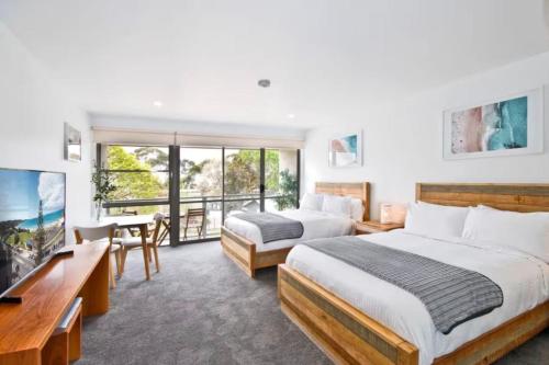 a hotel room with two beds and a television at Bay View Ocean Breeze in Lorne
