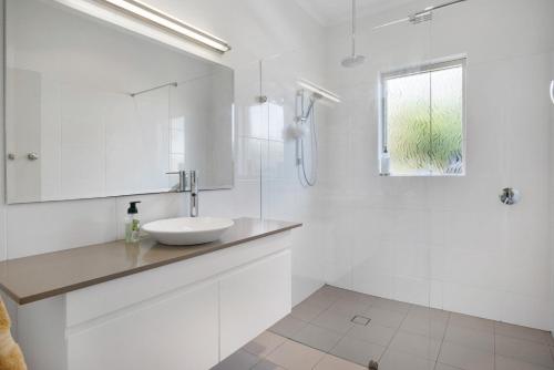 a white bathroom with a sink and a shower at Island View in Hayborough