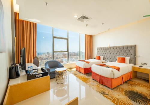 a hotel room with two beds and a television at وهج للشقق الفندقية Wahaj Hotel Apartments 2 in Kuwait
