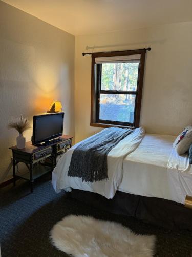 a bedroom with a bed and a tv and a window at Lakeside Condo Close to Slopes Excellent Location in Tahoe Vista