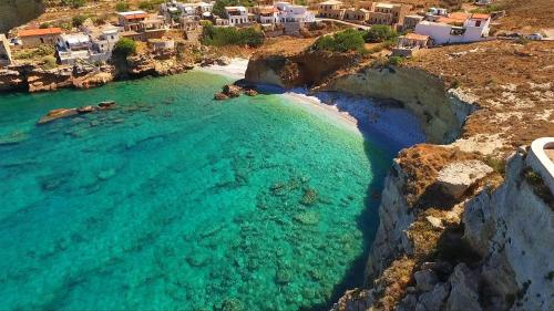 Kitta Mani Towerhouse - Mountain Views & Garden في Koíta: اطلالة جوية على شاطئ فيه ماء فيروزي