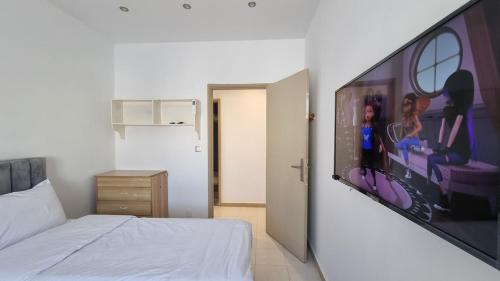 una camera con un letto e un'ampia immagine a parete di Confort & Soleil Akid Lotfi a Orano