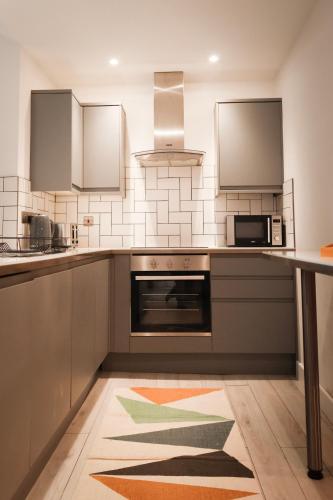 a kitchen with a stove and a microwave at Hull Central Comfort in Hull