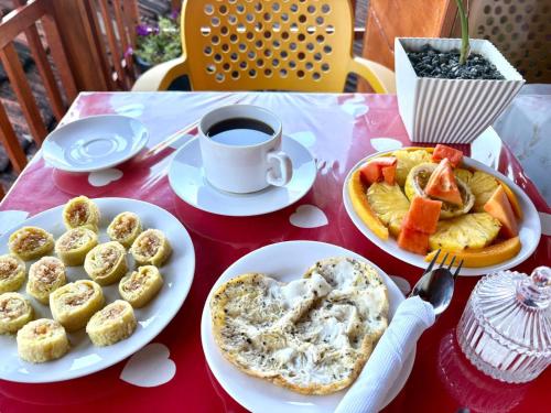 a table with plates of food and a cup of coffee at Wooden House Mirissa in Mirissa