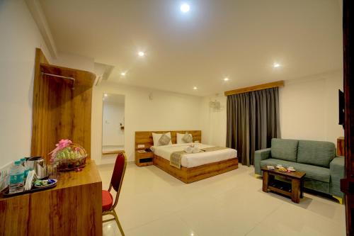 a hotel room with a bed and a couch and a table at Fly Inn Bangalore Airport in Muthugadahalli