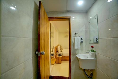 a bathroom with a sink and a shower and a toilet at Fly Inn Bangalore Airport in Muthugadahalli