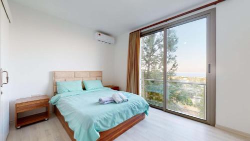 a bedroom with a bed and a large window at Villa Cypress Villas in Kyrenia