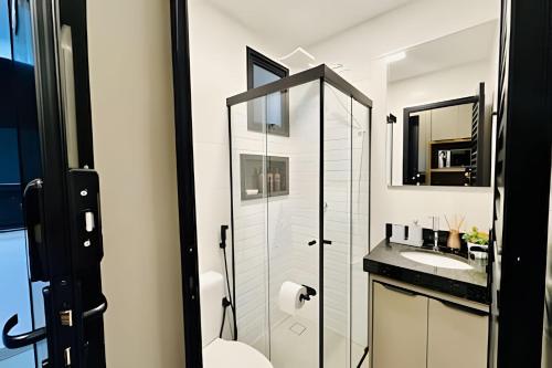 a bathroom with a toilet and a sink and a mirror at Studio Citrino – Localização perfeita próx. da Ufu in Uberlândia