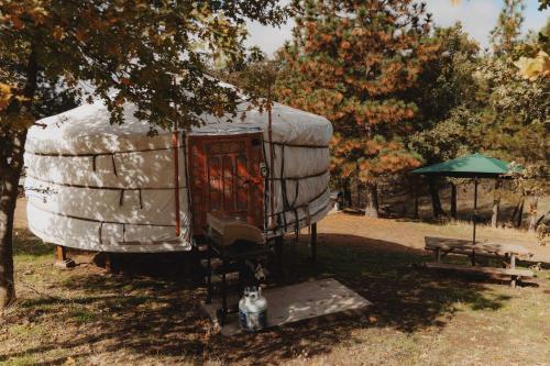 an outside view of a tent with a table and umbrella at Cosy yurt at a nature retreat in CA in Miramonte