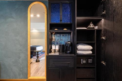 Armario negro con espejo en una habitación en Hotel Indigo Batumi - Old Town by IHG, en Batumi