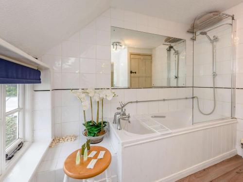 a bathroom with a tub and a sink and a mirror at 1 Bed in Tenterden oc-66342 in Tenterden