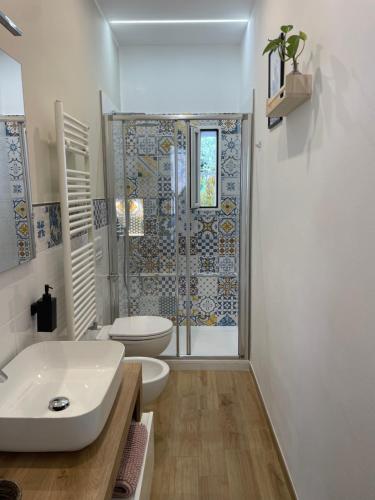 een badkamer met een wastafel, een toilet en een douche bij Cujo Apartment in La Spezia