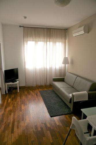 a living room with a couch and a television at Residence Le Terrazze in Trieste