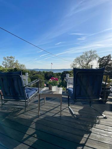dos sillas azules y una mesa en una terraza en Cozy Cabin With Sea View And Two Terraces, en Tjøme