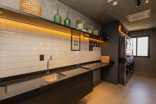 a bathroom with a sink and a counter with green vases at Sky Design Residence in Barueri