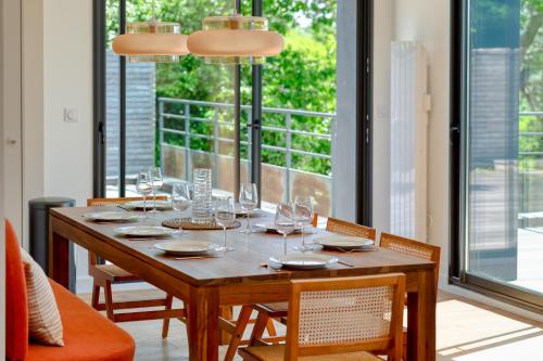 villa California - Villa d'exception avec vue mer panoramique - Veules-les-Roses في فول-لي-روز: طاولة غرفة الطعام مع كؤوس النبيذ عليها