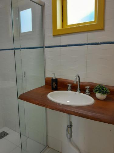 a bathroom with a sink and a glass shower at Recanto dos Açores in Florianópolis
