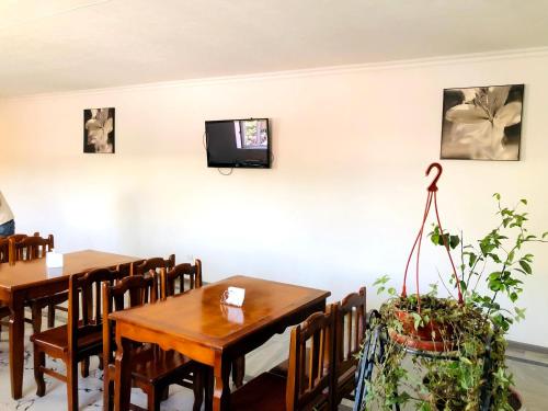 ein Esszimmer mit 2 Tischen und einem TV an der Wand in der Unterkunft maryamhotel in Navakhchinan