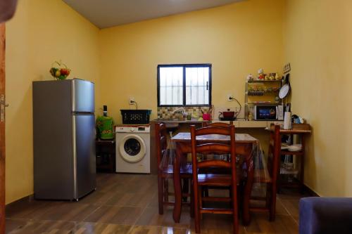 a kitchen with a refrigerator and a table with chairs at Ulises House in Luque