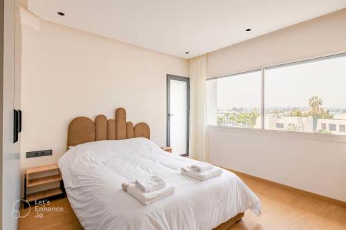 een slaapkamer met een groot bed met twee handdoeken erop bij Luxury Central 3BR 5min from Beach & Shopping in Casablanca