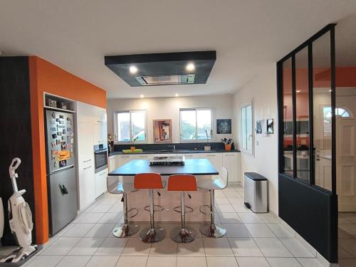 een keuken met een aanrecht en 2 krukken bij La Parenthèse colorée in Châteaumur