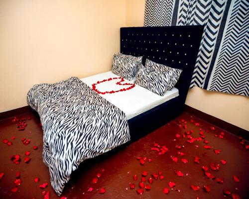 a bedroom with a bed with red petals on the floor at Mango Hostel Arusha in Arusha
