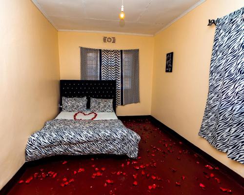 a bedroom with a bed with a red carpet at Mango Hostel Arusha in Arusha