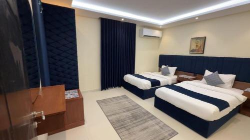 a hotel room with two beds and a television at اختيار السائح للشقق المخدومة in Jazan