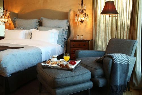 a hotel room with a bed and a chair with a tray of food at Casas Do Coro in Marialva