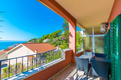 a balcony with chairs and a view of the ocean at Apartments Kunac in Podgora