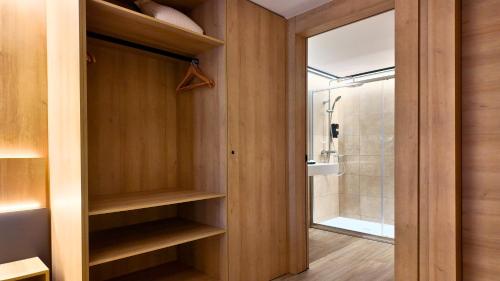 een badkamer met houten planken en een douche bij Hotel Catanies in Pas de la Casa