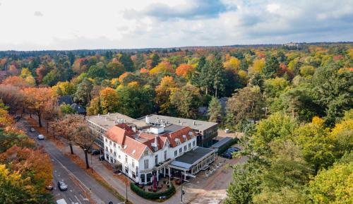 an aerial view of a large house in the forest at Fletcher Hotel Apeldoorn in Apeldoorn
