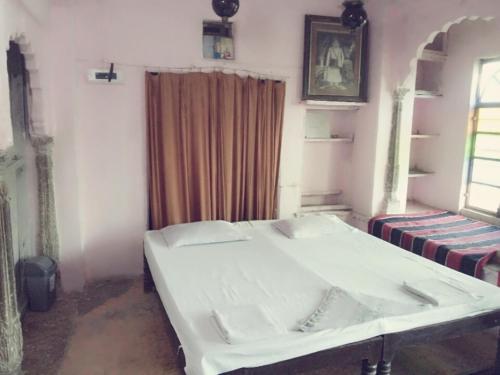 a room with a bed and a window with a curtain at Haveli Uma Megh Tourist Guest House in Būndi