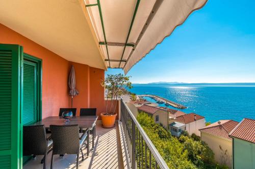 a balcony with a table and chairs and the ocean at Apartments Kunac in Podgora