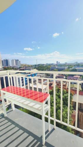 a red bench sitting on top of a roof at City BeSTAY at Mesatierra Garden for4 in Cabaguio