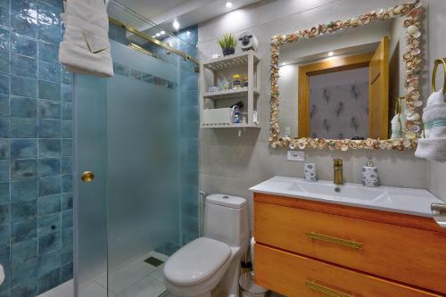 a bathroom with a toilet and a sink and a shower at Las Olas, Juan Dolio 2bed2bath Condo in Guayacanes