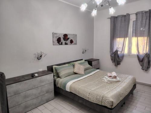 a bedroom with a bed with a dresser and a window at La casa di San Pio X in Agrigento