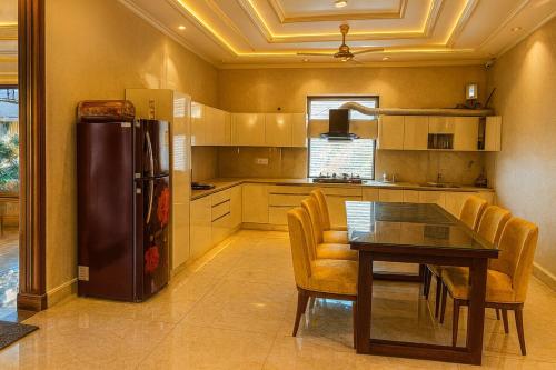Shail by Shubhs في Bhowāli: مطبخ مع طاولة طعام وثلاجة