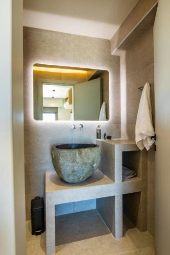 a bathroom with a bowl sink and a mirror at Anemelia Villas in Karpathos