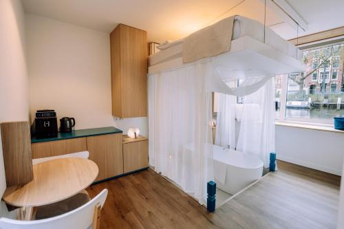 a kitchen with a table and a tub in a room at The Amsterdam Houseboat Family - de Jordaan Brand New Houseboat! in Amsterdam