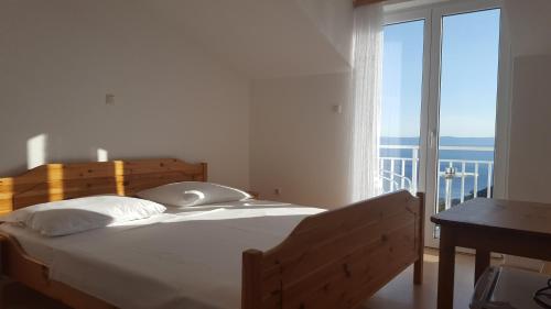 a bedroom with a bed and a large window at Guesthouse Bosankic in Makarska