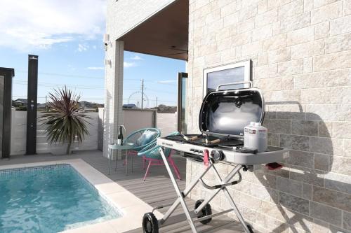a television on a stand next to a swimming pool at THE POOL HOUSE Kisarazu in Kisarazu
