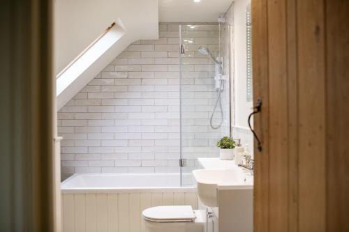 a bathroom with a tub and a toilet and a sink at Lark Rise in Boltby